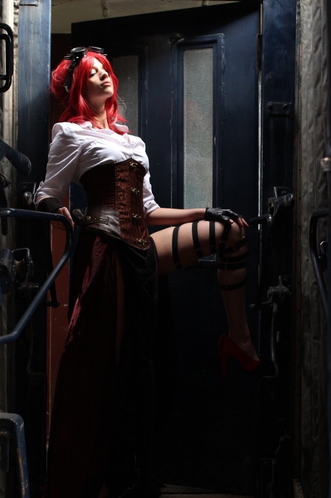 femme gothique en costume steampunk et cheveux longs de profil assise