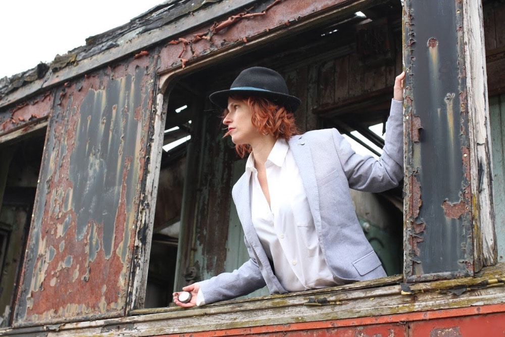 femme en tenue d'homme dans la fenêtre d'un ancien train 