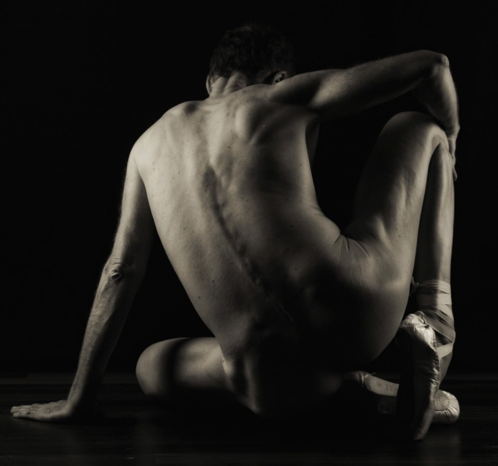 Séance shooting photo pour homme mature nu danseur yoga souplesse clair obscur noir et blanc de dos assis sur un pouf