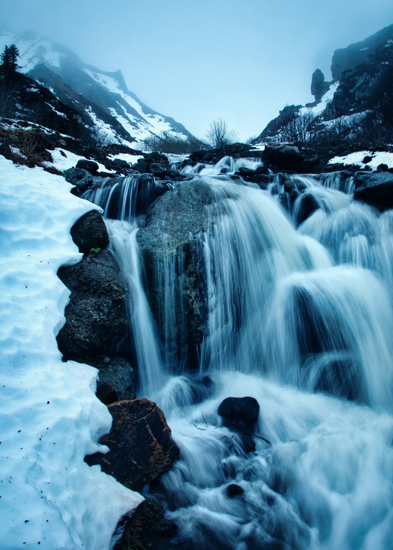 Cascade sous la neige en pose longue et brouillard