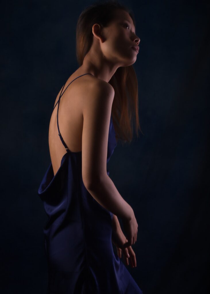l'estime de soi par la photo boudoir pour femme asiatique en clair obscur portant une nuisette bleu de profil
