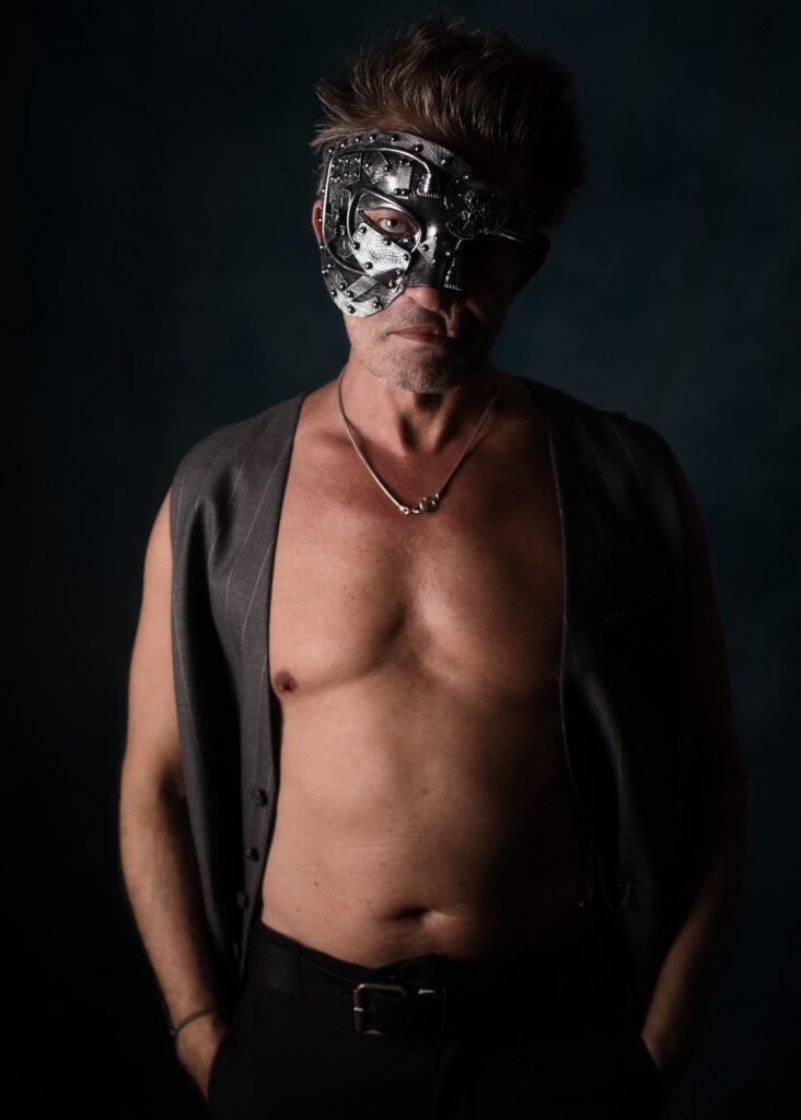 séance photo pour Homme masqué en nu artistique et clair obscur cicatrice portant un gilet