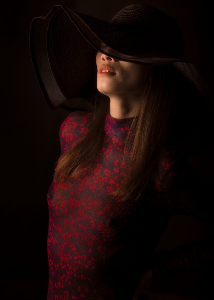 l'estime de soi par la photo boudoir d'une femme asiatique portant un chapeau noir et une body rouge
