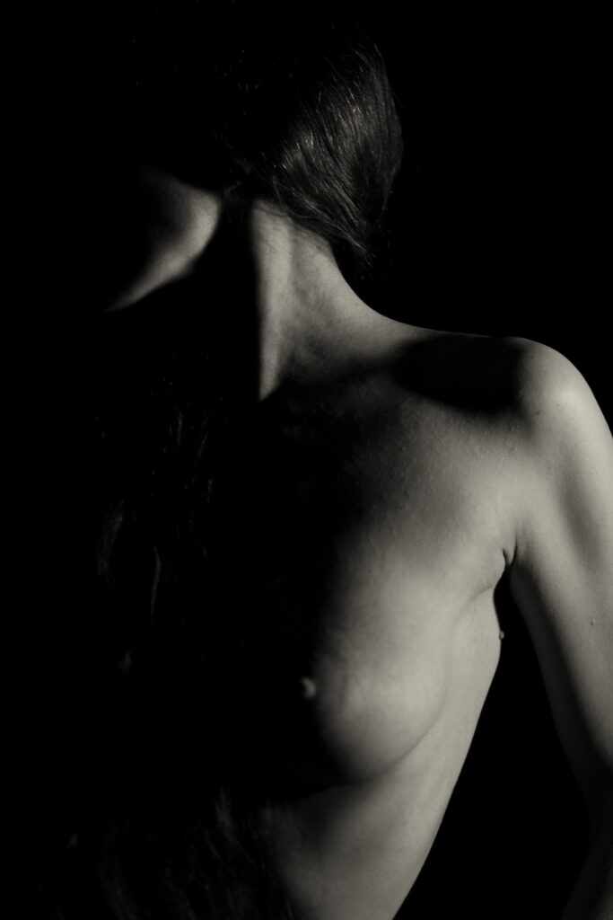 corps de femme en nu artistique en clair obscur profil visage caché