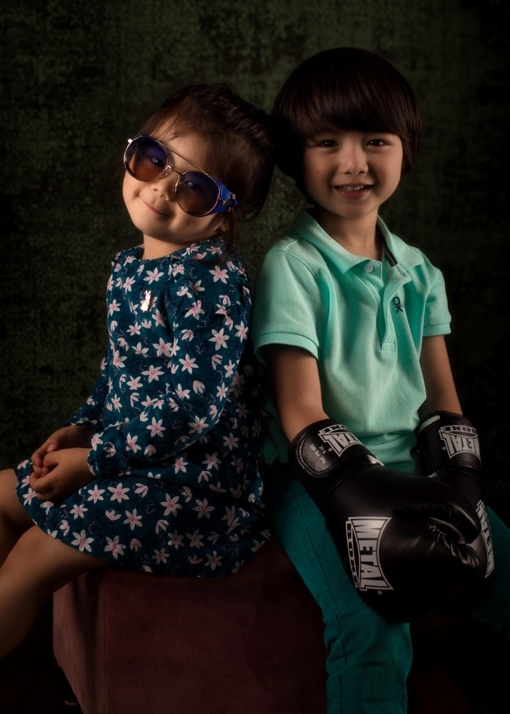 enfant garçon et fille enfant eurasien frère et soeur portrait sourire assis sur un tabouret dos à dos 