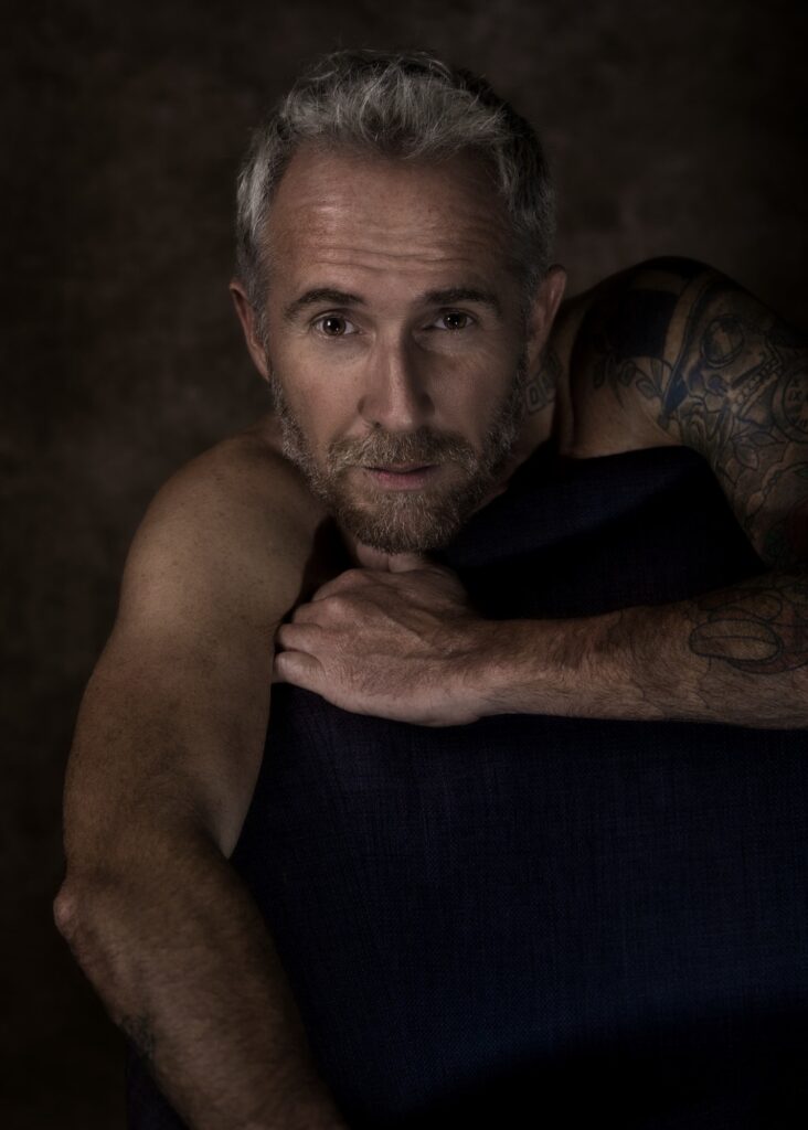 modèle homme photo en nu artistique portrait d'un homme mature barbu assis sur un fauteuil 