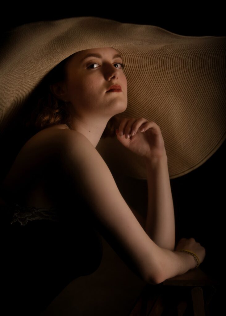 portrait d'une jeune femme style vintage de profil portant un grand chapeau en paille