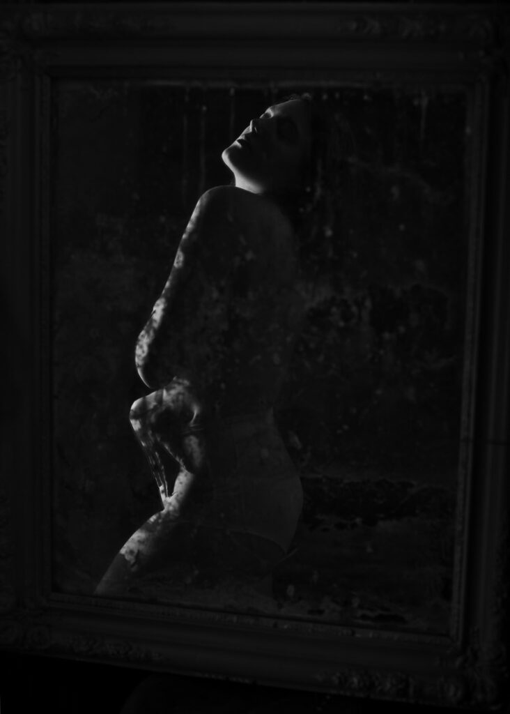 portrait d'une jeune femme style vintage acceptation de son image dans un miroir tenté vieilli noir et blanc