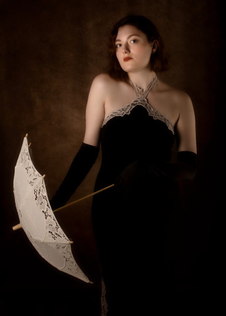 portrait d'une jeune femme style vintage portant une robe de soirée noire et une ombrelle blanche