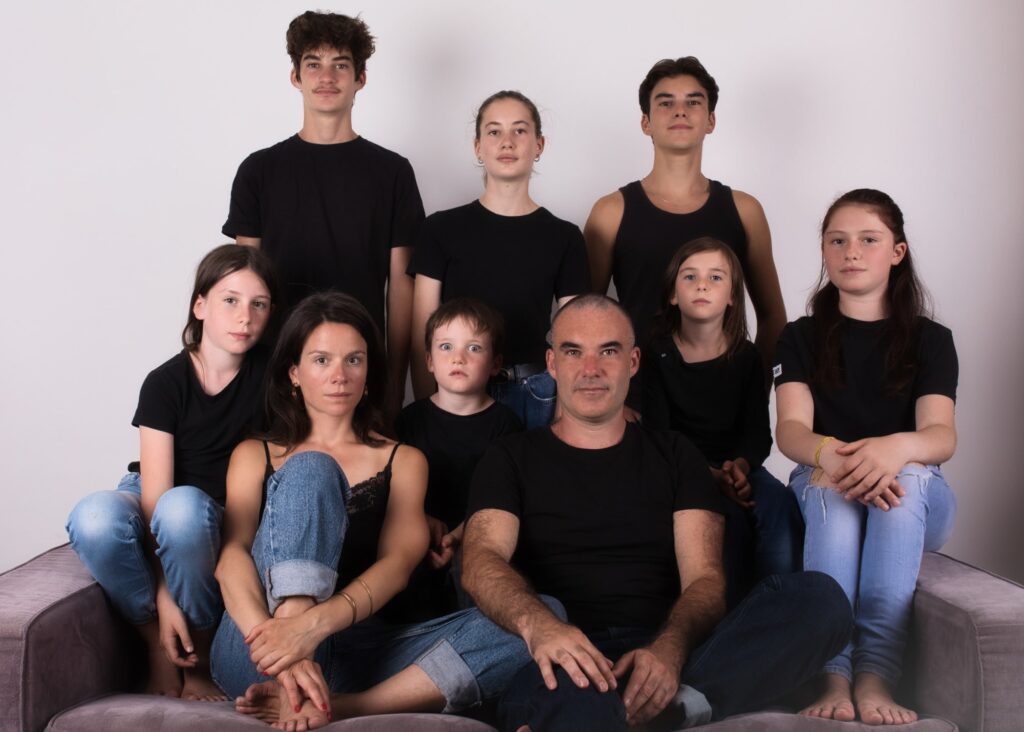 photographe famille portrait enfant à Montreuil Céline pivoine eyes groupe neuf personnes sérieux sur un canapé