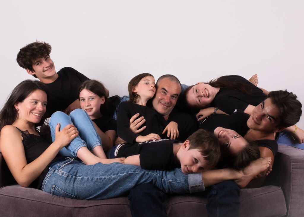photographe famille portrait enfant à Montreuil Céline pivoine eyes groupe neuf personnes sur un canapé en mode câlin