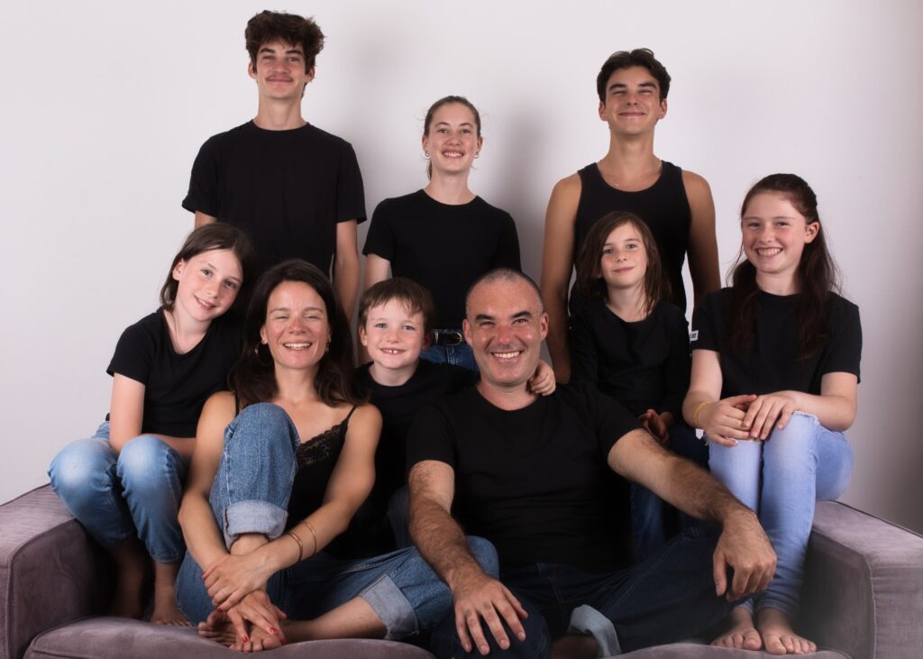 photographe famille portrait enfant à Montreuil Céline pivoine eyes groupe neuf personnes sur un canapé sourires