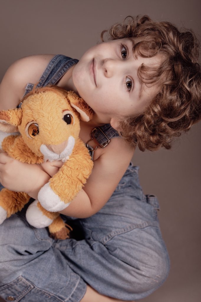 Séance photo portrait enfant avec Gabin et son doudou lion contreplongée sourire par femme photographe céline pivoine eyes au studio photo location à Montreuil près de Rosny sous bois