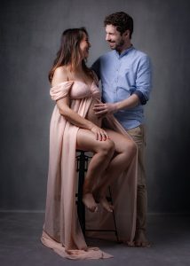 séance photo pour couple enceinte grossesse en robe de soirée saumon complicité par femme photographe Céline Pivoine Eyes au studio photo location à Montreuil près de Fontenay sous bois 