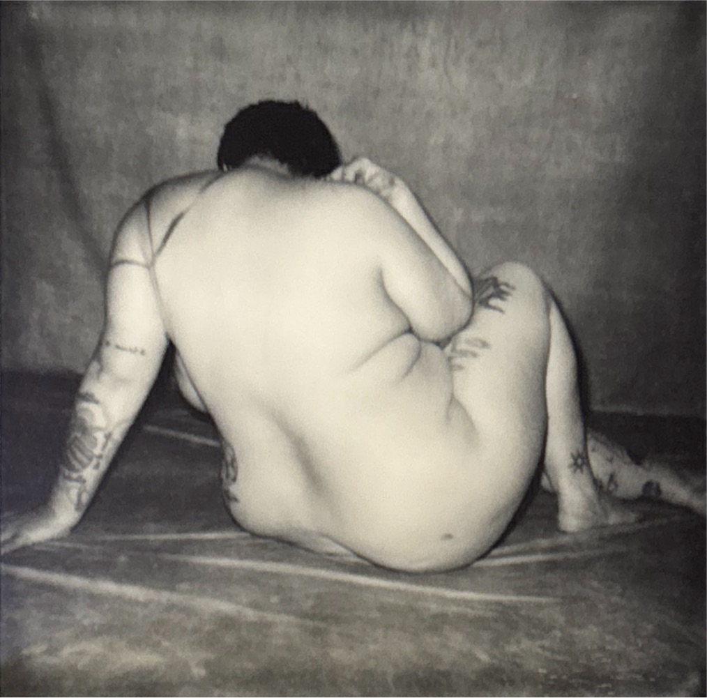 séance confiance en soi par le nu artistique pour femme ronde pulpeuse curvy grosse boudoir bien-être par céline pivoine femme photographe au studio photo location à Montreuil près de Paris polaroid noir et blanc dos assise 