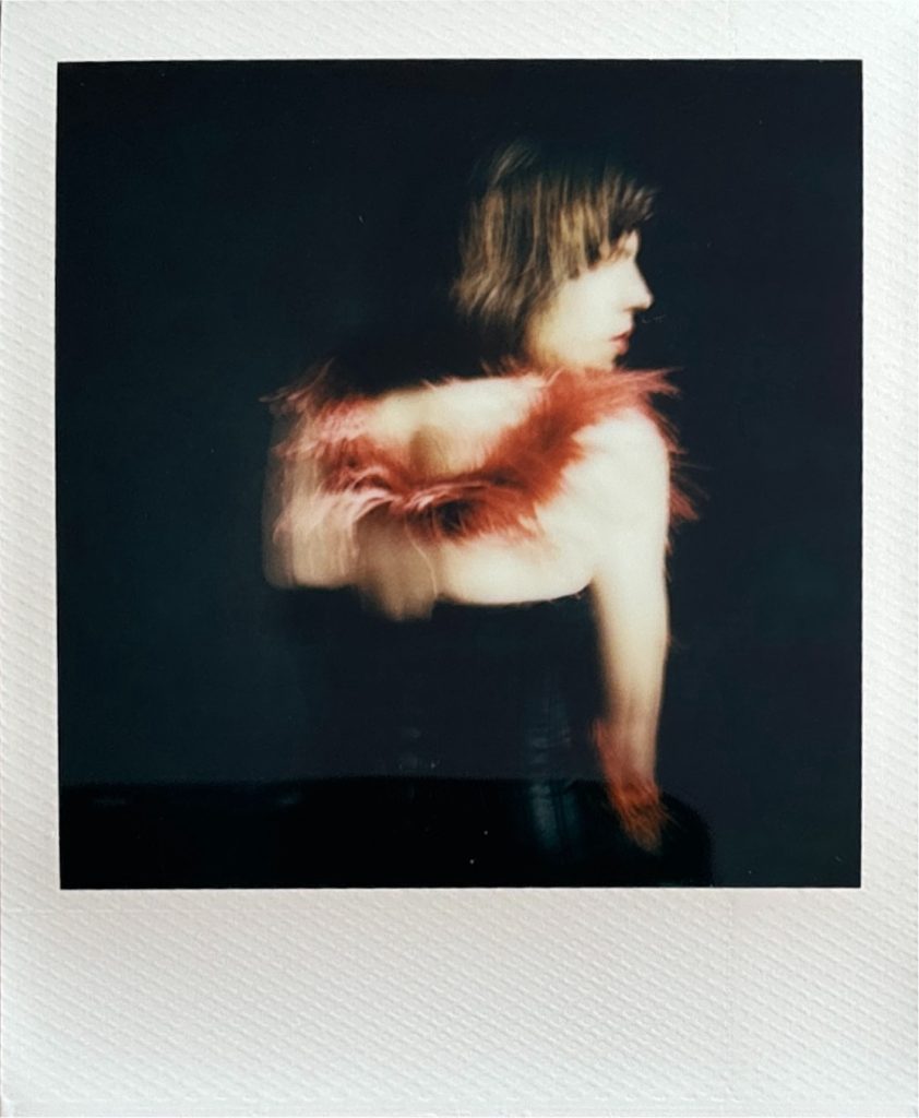 Louis modèle androgyne homme féminin polaroid séance photo par femme photographe céline pivoine eyes au studio photo location à Montreuil 93 près de Paris de dos avec boa