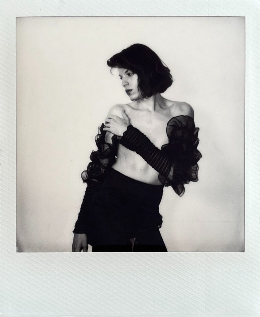 Louis modèle androgyne homme féminin polaroid séance photo par femme photographe céline pivoine eyes au studio photo location à Montreuil 93 près de Nogent sur Marne jupe et gants longs nb 