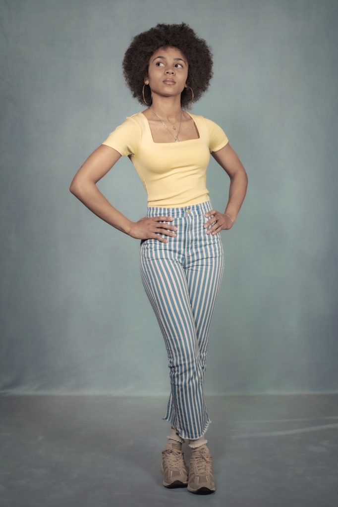 Séance book polas mannequin pour agence avec Séréna estime de soi métisse cheveux afro par femme photographe Celine Pivoine eyes au studio photo location à Montreuil 93 près de Rosny sous bois debout tenue de ville pantalon rayé