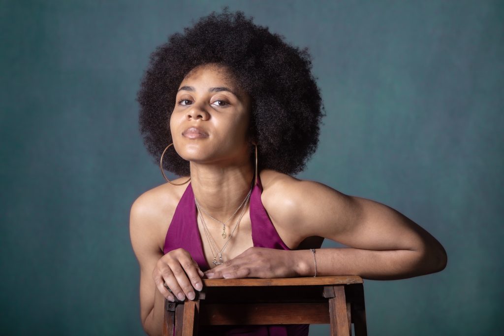 Séance book polas mannequin pour agence avec Séréna estime de soi métisse cheveux afro par femme photographe Celine Pivoine eyes au studio photo location à Montreuil 93 près de Fontenay sous bois assise chaise robe rose