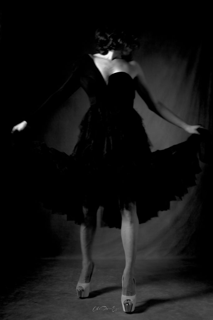 Séance photo shooting boudoir pour homme féminin robe et talons hauts noir et blanc debout avec Dione par femme photographe Céline Pivoine Eyes au studio photo location à Montreuil 93 près de Paris
