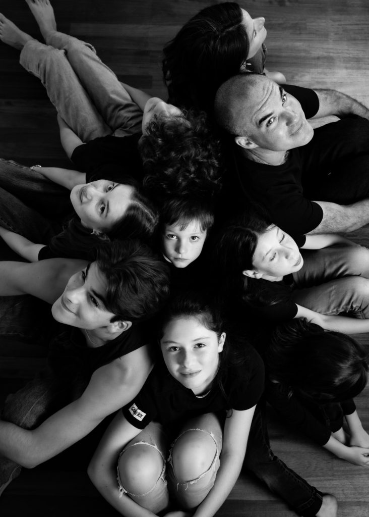photographe famille portrait enfant à Montreuil 93 près de Saint Mandé au studio photo location Céline pivoine eyes femme photographe groupe neuf personnes au sol noir et blanc