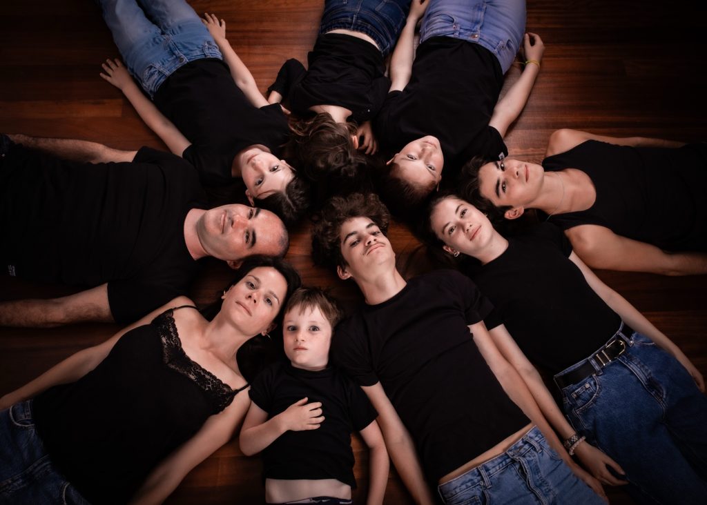 photographe famille portrait enfant à Montreuil 93 en Île de France au studio photo location Céline pivoine eyes femme photographe groupe neuf personnes au sol