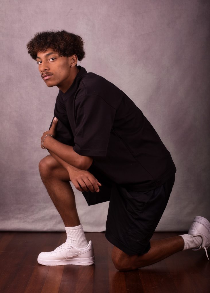 Séance photo book modèle débutant pour jeune homme ado métisse avec Jules souriant de profil en tenue de  sport par Céline pivoine eyes femme photographe au studio photo location 93 à Montreuil près de Noisy le sec