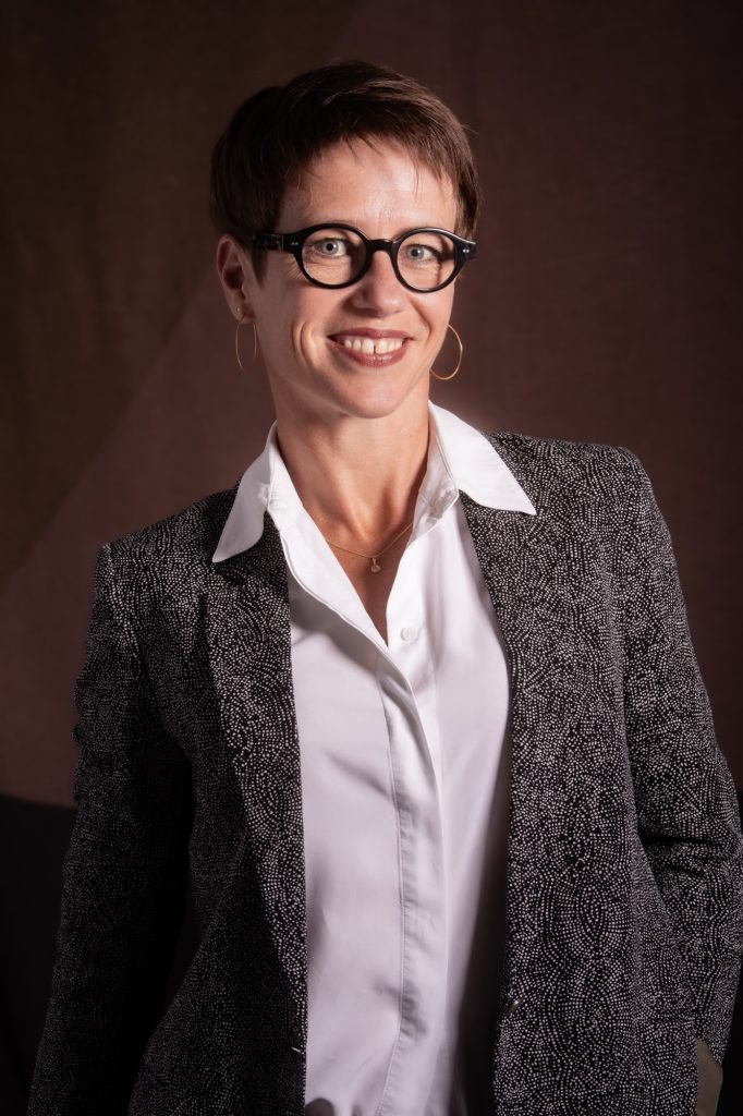 Séance photo profil professionnelle portrait cv Linkedin pour femme avec Lucie par femme photographe céline pivoine eyes au studio photo location à Montreuil près de Rosny sous bois en veste et chemise sourire et lunettes noires