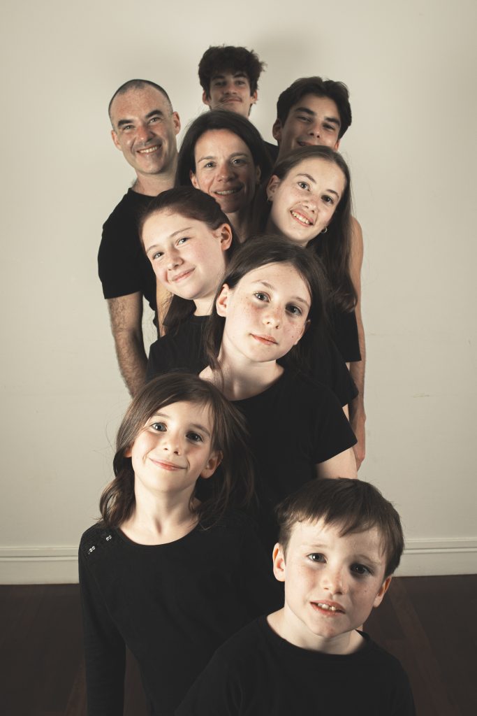 photographe famille portrait enfant groupe à Montreuil 93 près de Nogent sur marne au studio photo location Céline pivoine eyes femme photographe groupe neuf personnes alignées portrait