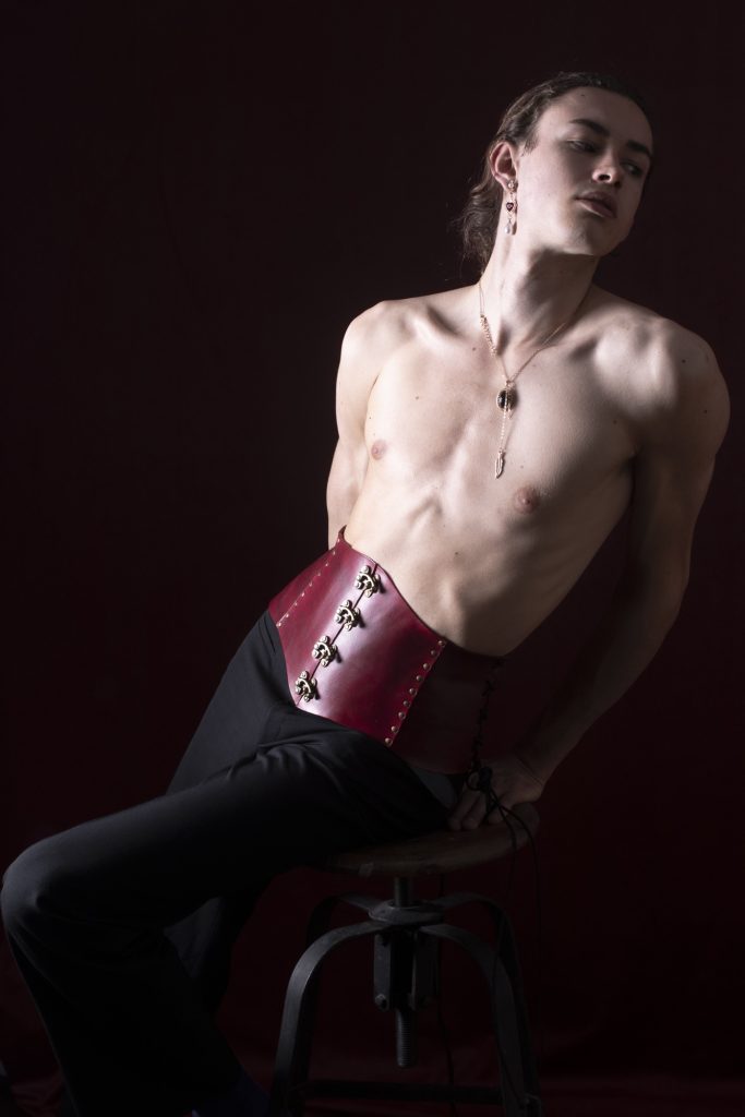 Séance photo shooting pour modèle homme androgyne les féminins par femme photographe céline pivoine eyes au studio photo location à Montreuil 93 près du Val de Marne en serre-taille cuir rouge torse nu