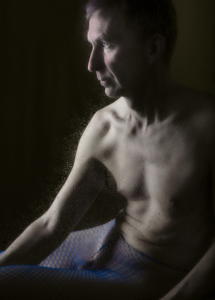 séance photo shooting pour modèle vivant homme nu avec Marco par femme photographe céline pivoine eyes au studio photo location à Montreuil 93 près de Vincennes portrait vintage en résilles jaunes assis de profil les féminins