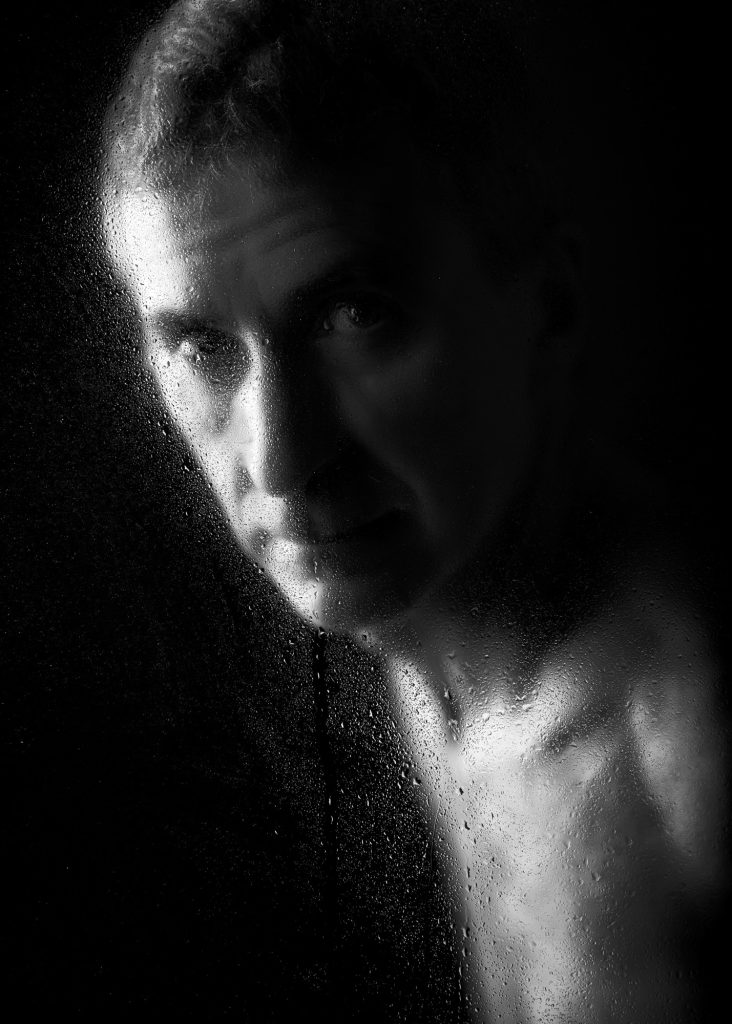 séance photo shooting pour modèle vivant homme nu avec Marco par femme photographe céline pivoine eyes au studio photo location à Montreuil 93 près de Vincennes portrait noir et blanc gouttes derrière une vitre
