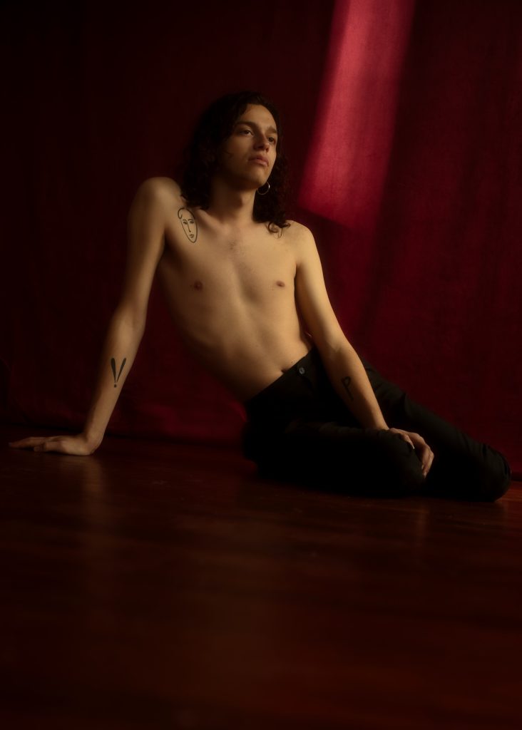séance photographe queer lgbtqia+ androgyne série les féminins avec Thom homme modèle débutant par céline pivoine eyes femme photographe au studio photo location à Montreuil 93 en région parisienne boudoir fond rouge au sol parquet