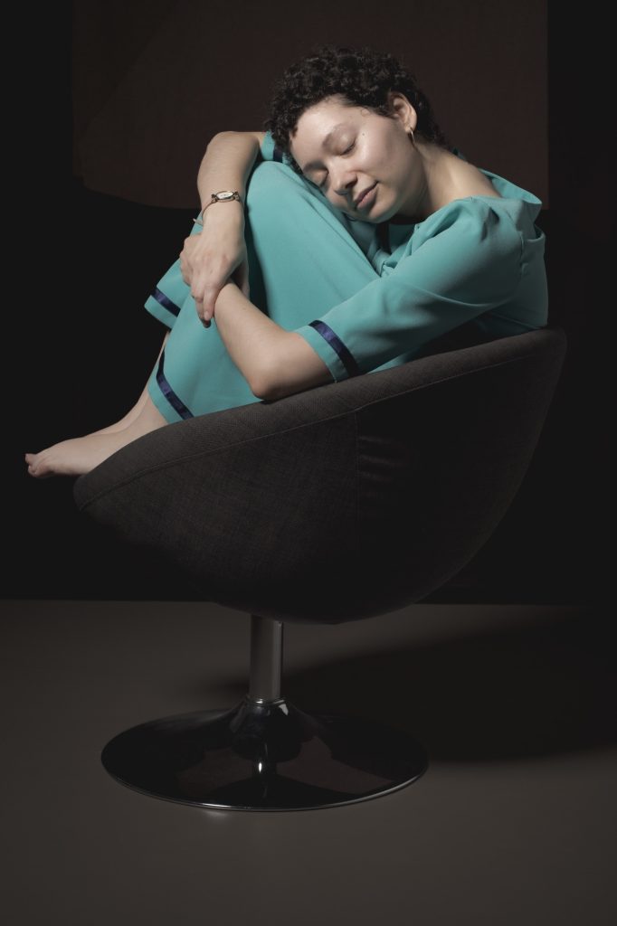 Séance photo shooting pour Eva femme autiste estime de soi enfant intérieur connexion portrait par Céline Pivoine Eyes femme photographe au studio photo location à Montreuil 93 près de Noisy le sec yeux fermés robe verte sur fauteuil boule