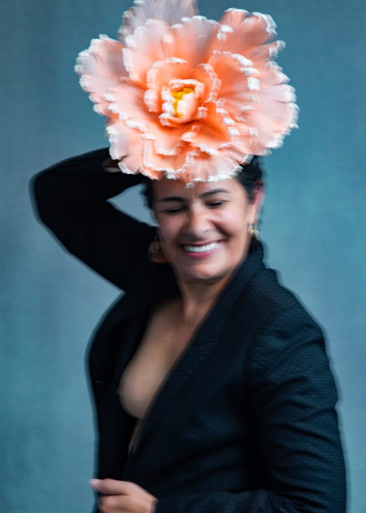 séance photo résilience cancer maladie estime de soi pour femme sénior mature sexagénaire avec Myriam par Céline pivoine eyes femme photographe au studio photo location à Montreuil 93 près de Paris sourire avec fleurs orange et veste noire