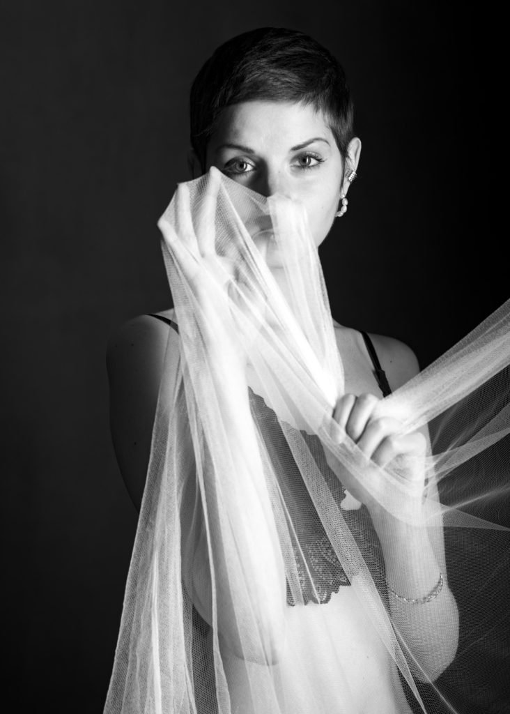 Séance photo boudoir estime de soi résilience cancer du sein avec Charlotte jeune femme en guérison par femme photographe céline pivoine eyes au studio photo location à Montreuil près de Rosny sous Bois derrière un voile portrait noir et blanc en lingerie