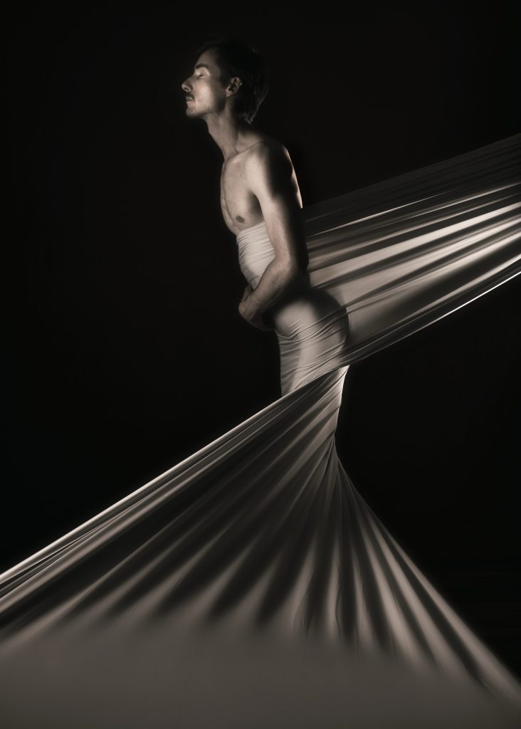 séance photo shooting pour modèle homme mince musclé lgbtqia avec Christophe Gallo acteur par femme photographe céline pivoine eyes au studio photo location à Montreuil près de Paris nu artistique drapé voile robe sépia de profil