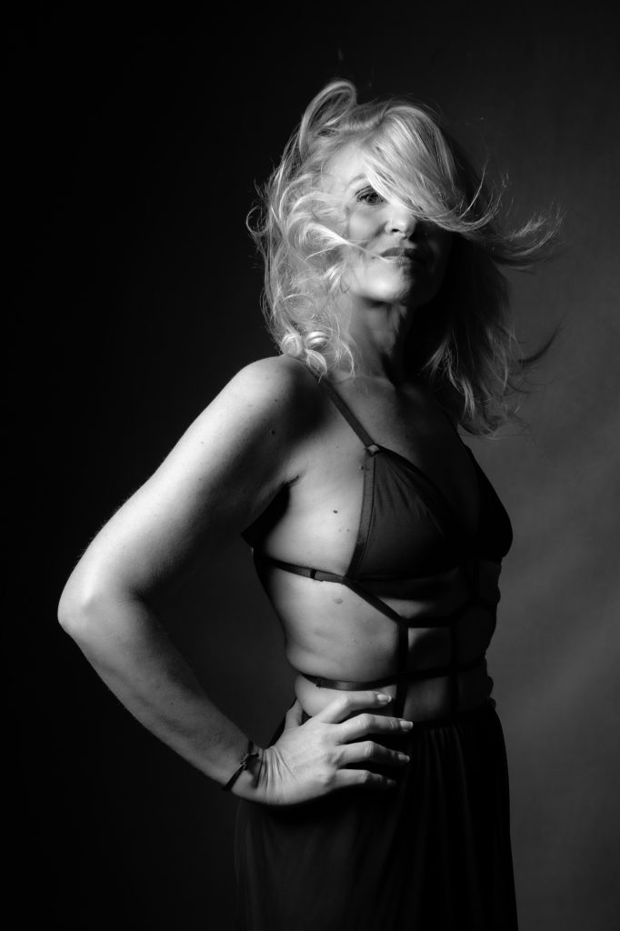 Séance photo shooting boudoir pour femme sensualité lingerie avec Karinne modèle sénior tda par femme photographe Céline Pivoine eyes au studio photo location à Montreuil 93 près de Saint Mandé debout cheveux au vent dans une lingerie femme fatale noir et blanc