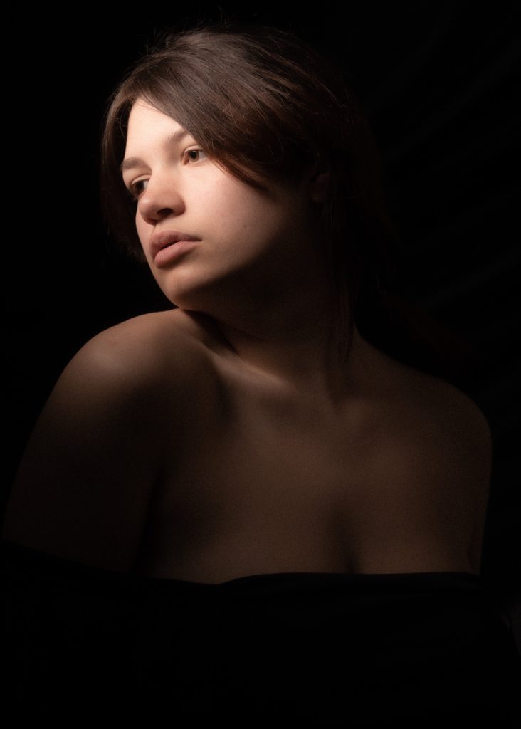 Séance confiance en soi boudoir artistique pour jeune femme pulpeuse ronde portrait clair obscur de profil