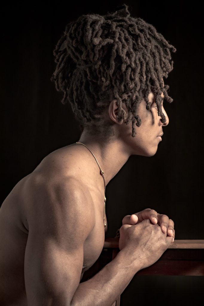 Séance photo portrait boudoir pour homme métisse jeune musclé portrait avec des dreadlocks profil peau mat torse nu