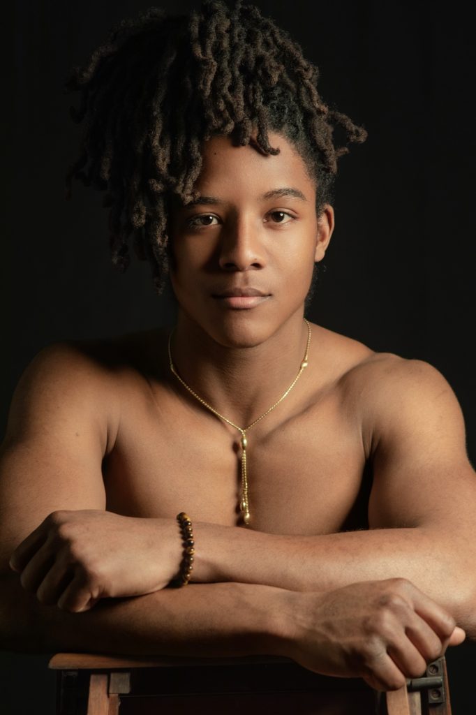Séance photo portrait boudoir pour homme métisse jeune musclé portrait avec des dreadlocks peau mat torse nu