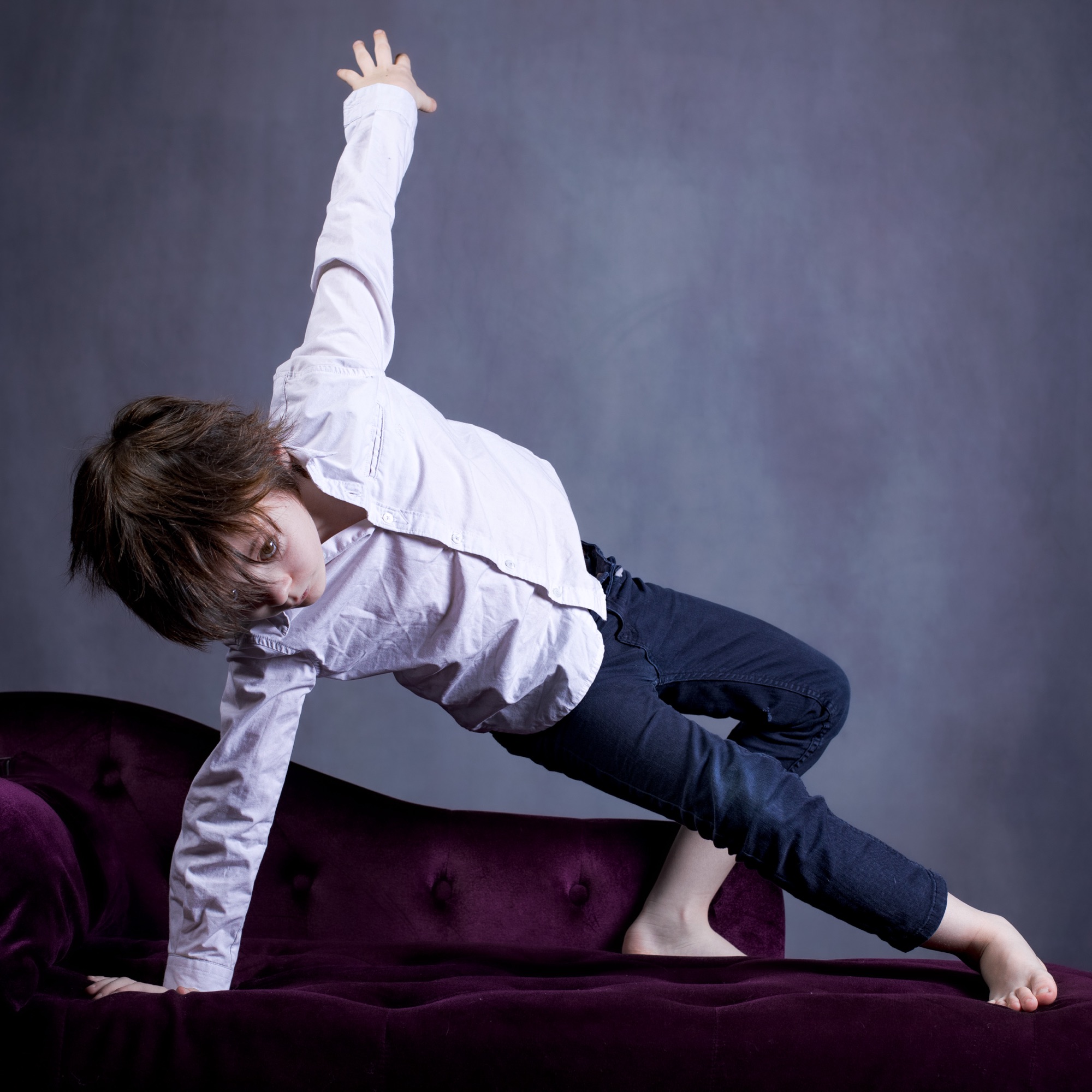 séance photo portrait enfant kid avec Camille 7 ans en chemise et mouvement sur un divan par femme photographe au studio photo location à Montreuil 93 Céline Pivoine Eyes près de Nogent sur Marne