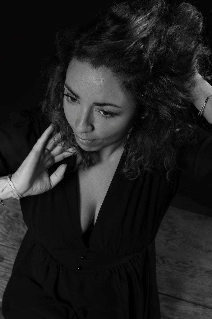 Séance portrait estime de soi avec Vanessa noir et blanc décolletée en robe noire se coiffant