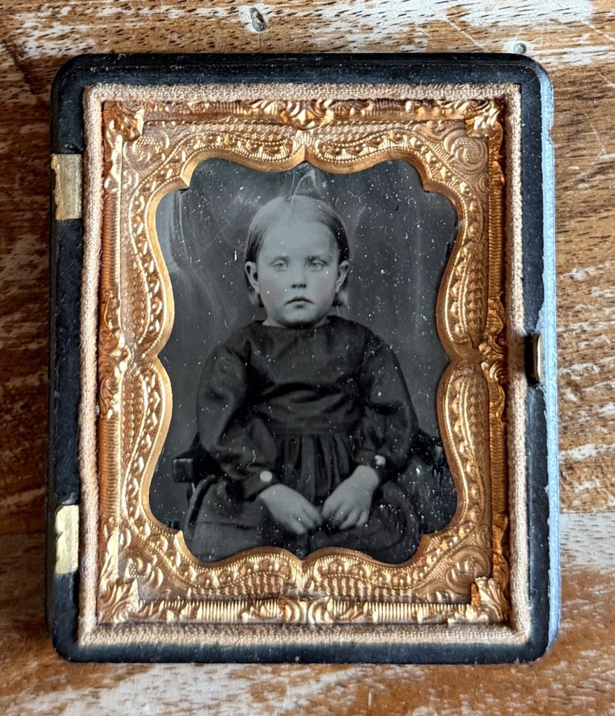 Ambrotype dans un écrin à charnière de type « Union case » : portrait d'un jeune enfant blond en robe sombre, joues rehaussées de rose, vers 1855-1865.
