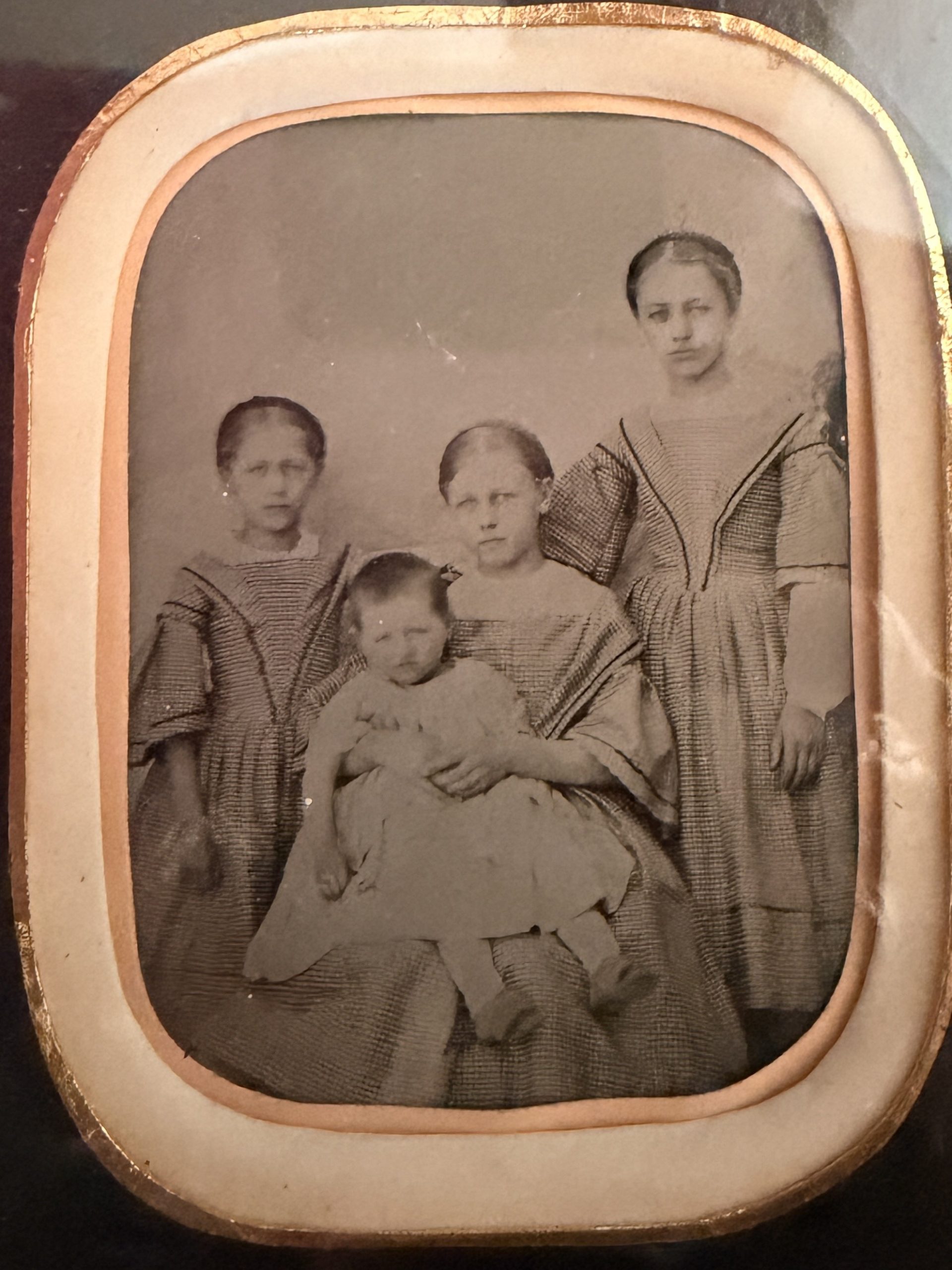 Ambrotype dans un cadre en bois doré : portrait de groupe de quatre enfants (trois fillettes et un jeune enfant), robes à carreaux, vers 1855-1865.